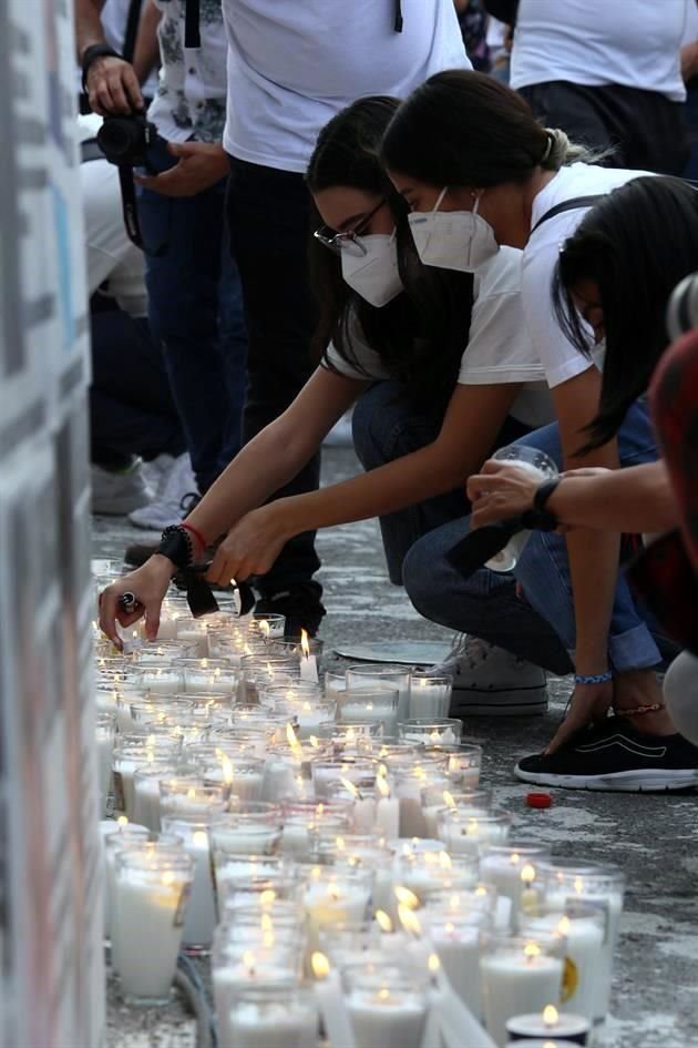 En torno a los carteles de personas desaparecidas, los asistentes a la marcha encendieron veladoras.