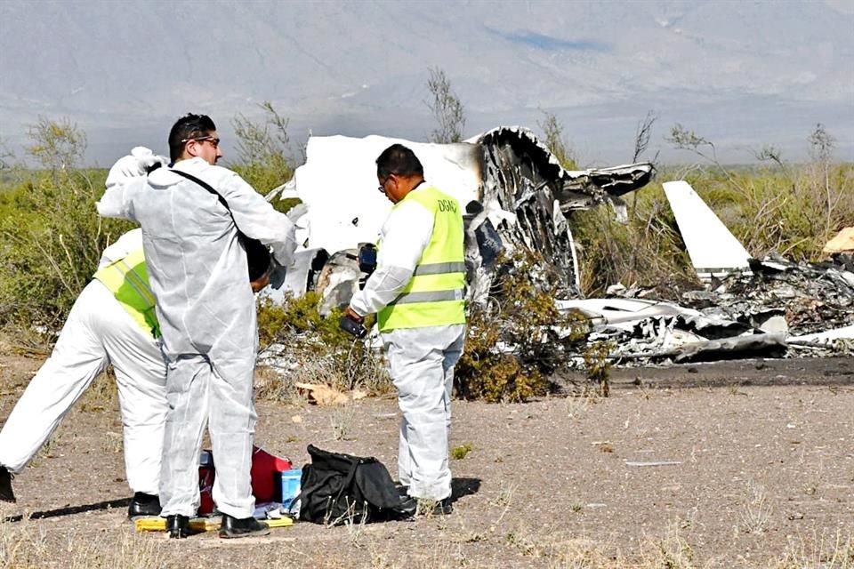 Peritos de la Fiscalía General de Coahuila y personal de la Dirección General de Aeronáutica Civil trabajan en la zona del accidente del jet ejecutivo.