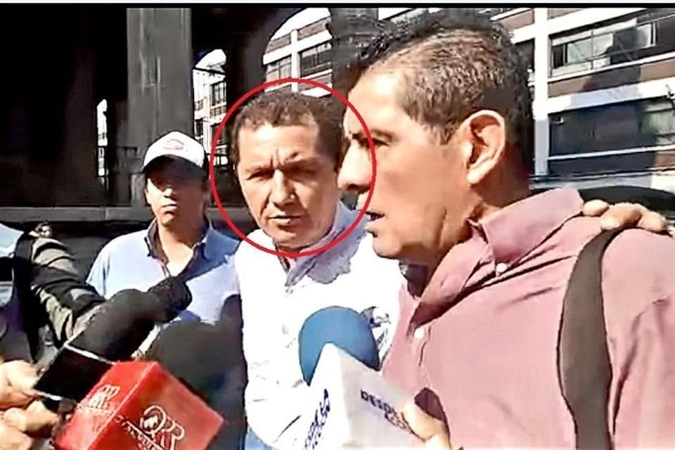 Gilberto Alcalá (rojo), Secretario de Desarrollo Social de Morelos, era entrevistado cuando Jesús García, líder de comerciantes, se acercó un momento. Minutos después el agresor disparó en cuatro ocasiones en contra de García.