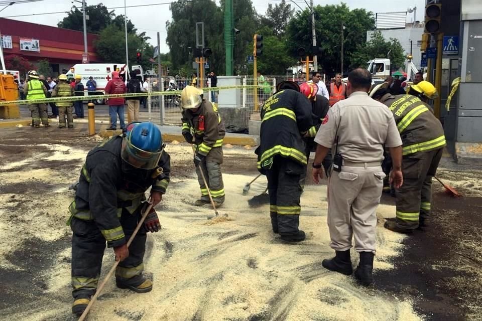 Bomberos se dieron a la tarea de echar aserrín y arena para limpiar el diésel que se derramó con el choque.