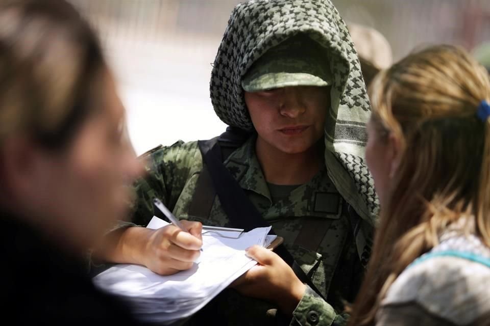 Un miembro de la Guardia Nacional con una migrante, luego de su detención en Ciudad Juárez hace tres días.