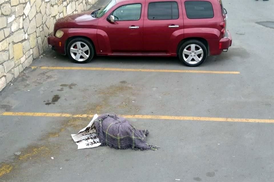Clientes del negocio reportaron a las autoridades que al fondo del estacionamiento estaba una persona tirada envuelta en una cobija gris.