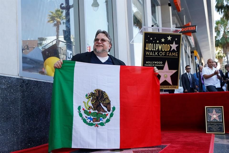 Guillermo del Toro posa con la bandera de México sobre la estrella en su honor.