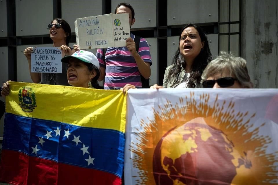 Un grupo de personas participa en una manifestación para pedir atención por los incendios de la selva amazónica frente a la Embajada de Brasil en Caracas, Venezuela.