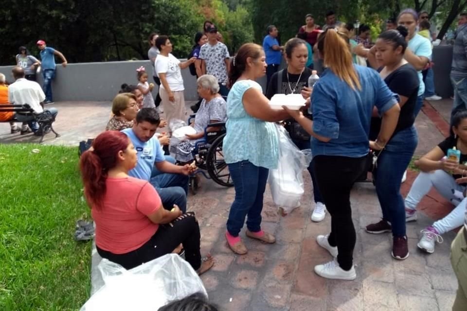 Una mujer encabezó el reparto de lonches para las personas acarreadas, mientras esperaban en la Macroplaza a que concluyera el Informe del Gobernador.