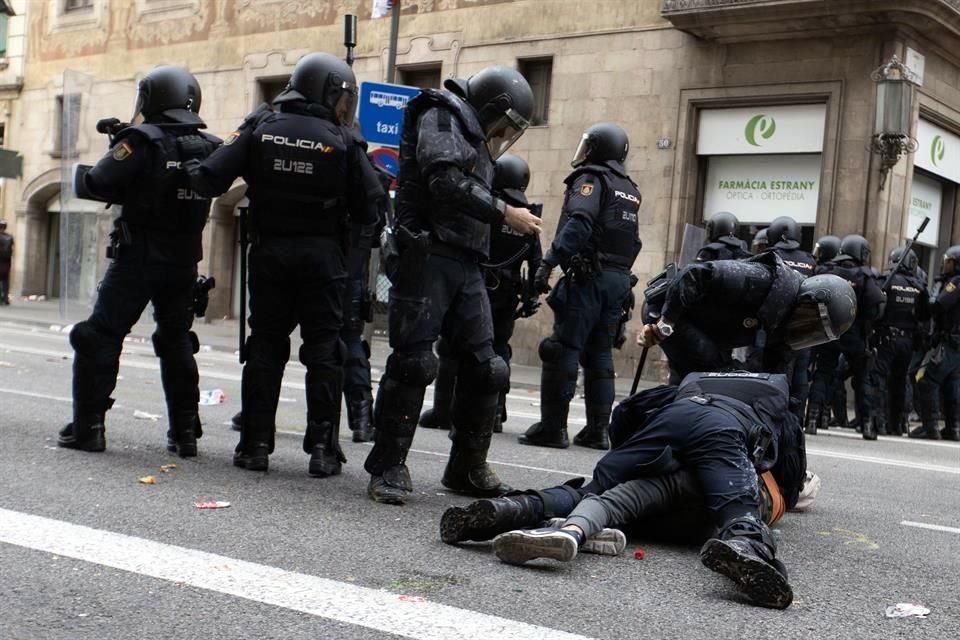 Agentes de la Policía Nacional detienen a un joven durante las protestas que se están produciendo ante la comisaria de la Policía Nacional de Via Laietana, en Barcelona.