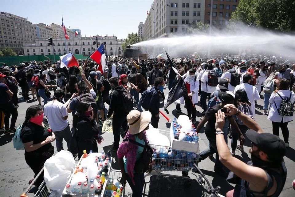 Carabineros dispersan a manifestantes que protestan frente al Palacio de La Moneda, en Santiago.