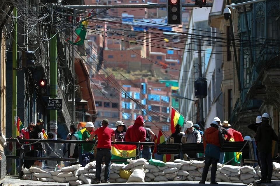 Ciudadanos bolivianos resguardan un ingreso a Plaza Murillo, donde los policías se replegaron, este sábado en La Paz, Bolivia