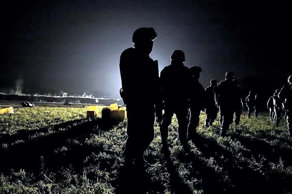 Militares en el campo de alfalfa que ardió tras una explosión causada por robo de gasolina el 18 de enero del 2019; tras ellos hay bidones y cadáveres.