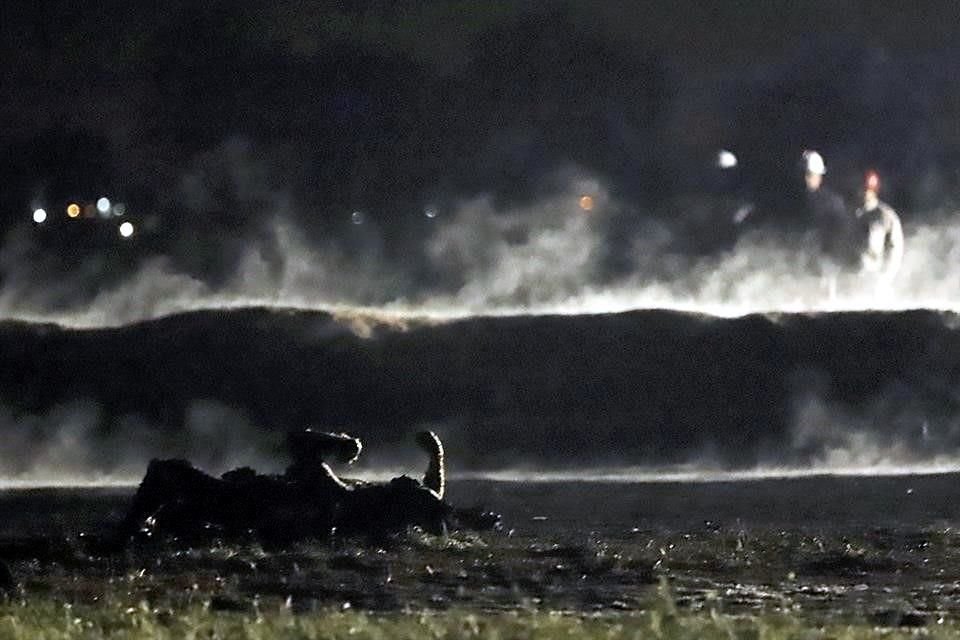 El cuerpo de una de las 135 víctimas yace en el terreno humeante tras el incendio desatado durante la ordeña de un ducto de Pemex.