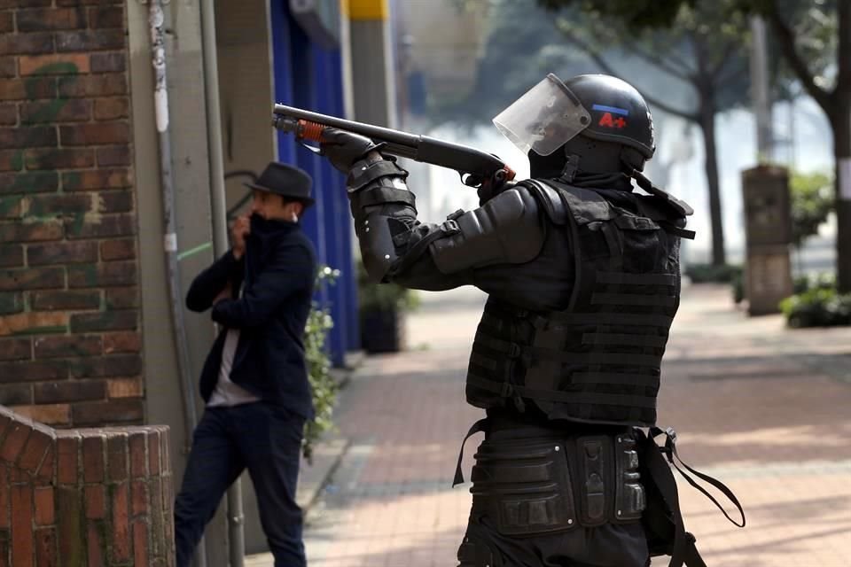 Un Policía apunta a manifestantes durante la protesta de este sábado.