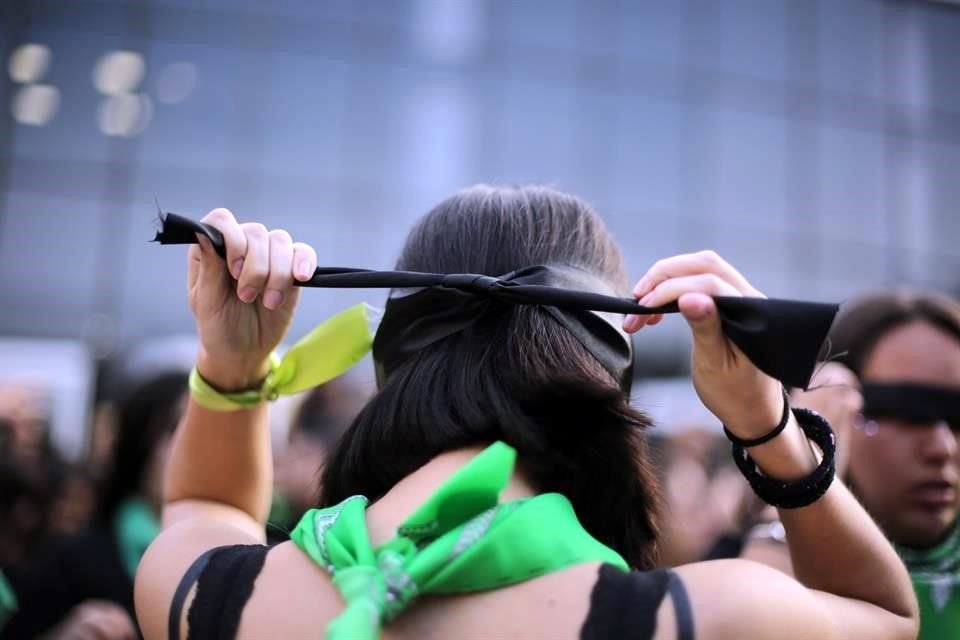 Vestidas de negro y con pancartas a sus pies, las mujeres se reunieron en la explanada de Centro Estudiantil ataviadas con pañuelos verdes y las vendas negras en los ojos.