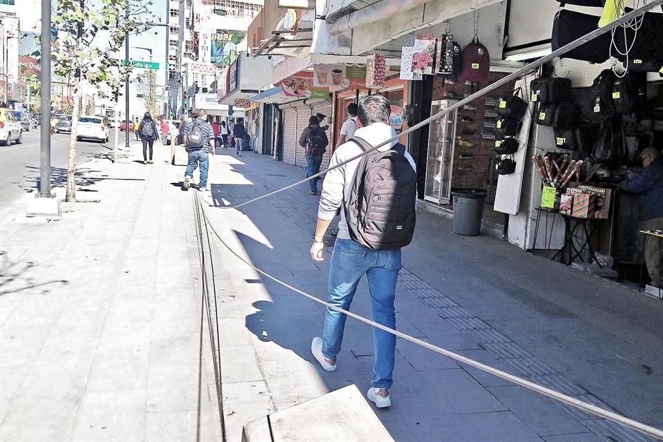 Los peatones que usan las nuevas banquetas ampliadas en el Centro se tipan con diversos obstáculos que los ponen en riesgo.