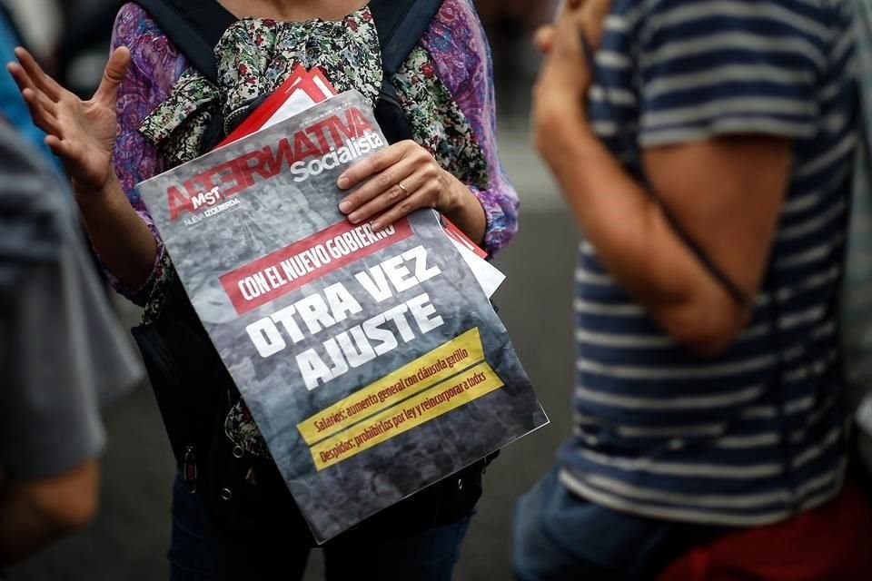 Una mujer sostiene un cartel durante una protesta encabezada por el grupo político Frente de Izquierda contra la Ley de Gestión de la Sostenibilidad de la Deuda Pública Externa.