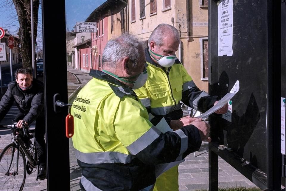 Funcionarios usan máscaras San Fiorano,una de las ciudades aisladas por el coronavirus.