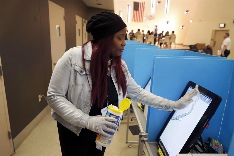 Una funcionaria electoral limpia una de las pantallas de votación temprana en Chicago.