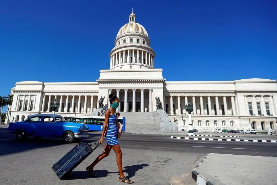 Una mujer camina frente al Capitolio, en La Habana, Cuba.