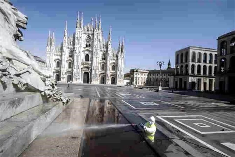 Un trabajador desinfecta la Plaza del Duomo en Milán, Italia.