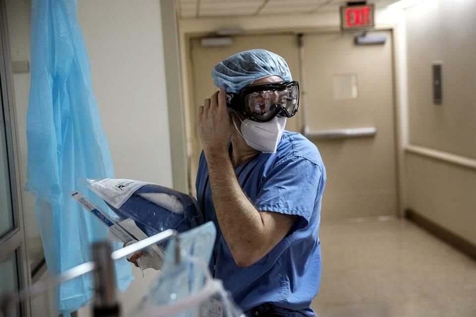 Joshua Rosenberg se ajusta su equipo protector antes de entrar a una sala con pacientes de Covid-19.