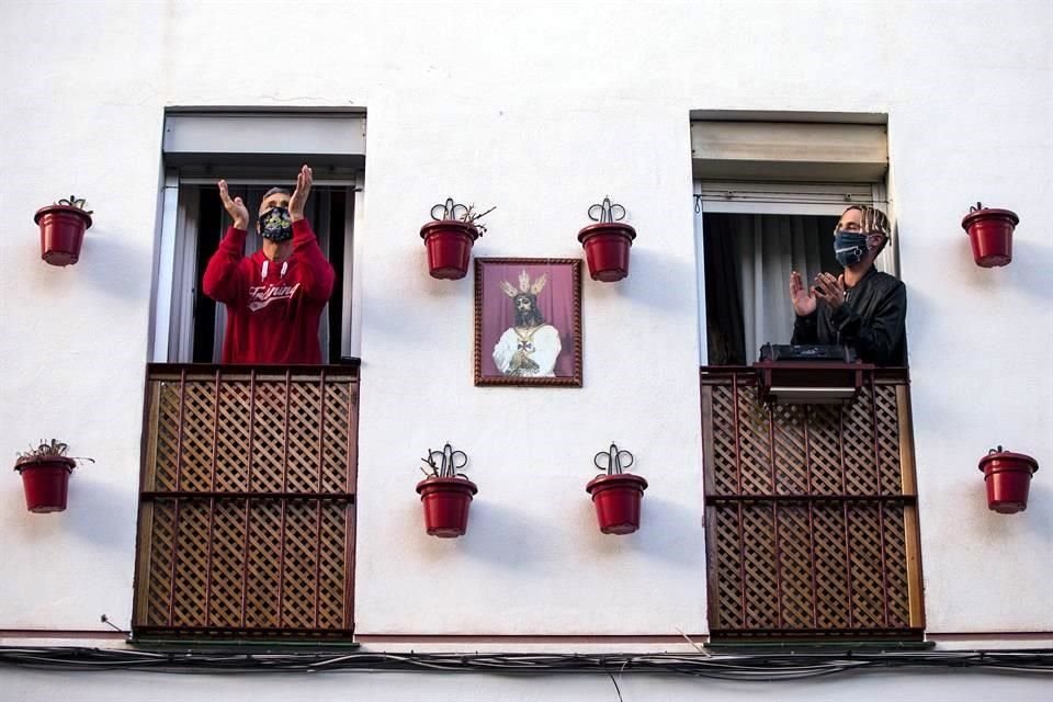 Vecinos del barrio de la Trinidaden Málaga, aplauden a trabajadores de salud durante la vigésima tercera jornada de confinamiento tras decretarse el estado de alarma por el nuevo coronavirus.