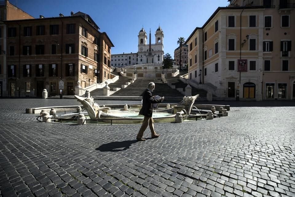 Persona camina en medio de una desolada Piazza di Spagna, en Roma.