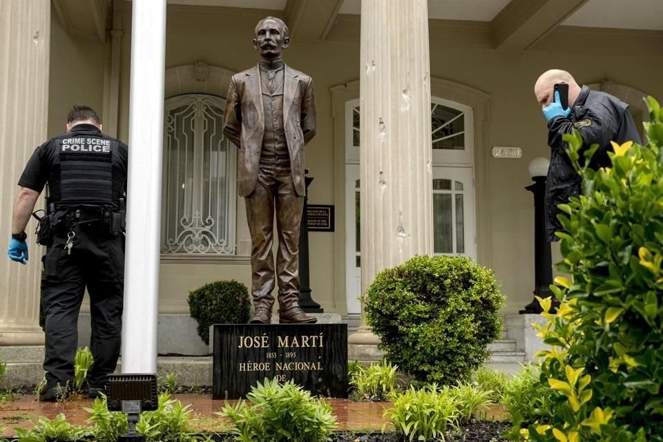 Miembros del Servicio Secreto revisan la Embajada de Cuba, cerca de la estatua de José Martí, donde son visibles impactos de bala.