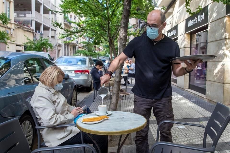 Una mujer desayuna en la terraza de una cafetería en Zaragoza.