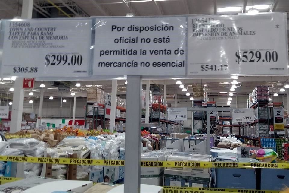 Personal de Costco colocó letreros para avisar a los clientes de la prohibición de vender mercancía no esencial.
