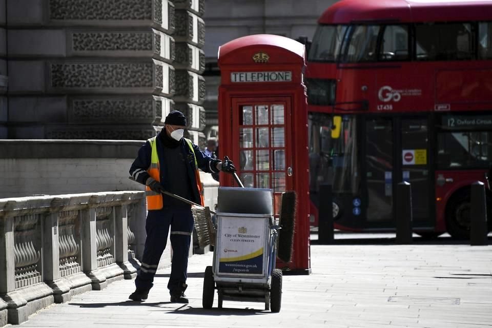 un trabajador de limpieza recoge basura cerca del Parlamento en Londres.