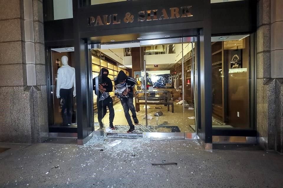 Personas saqueando un negocio en la Avenida Madison en Manhattan.