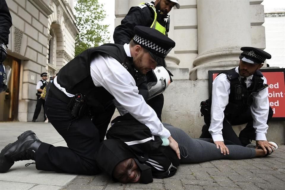 Policías detienen a un manifestante cerca del Parlamento de Reino Unido en Londres.