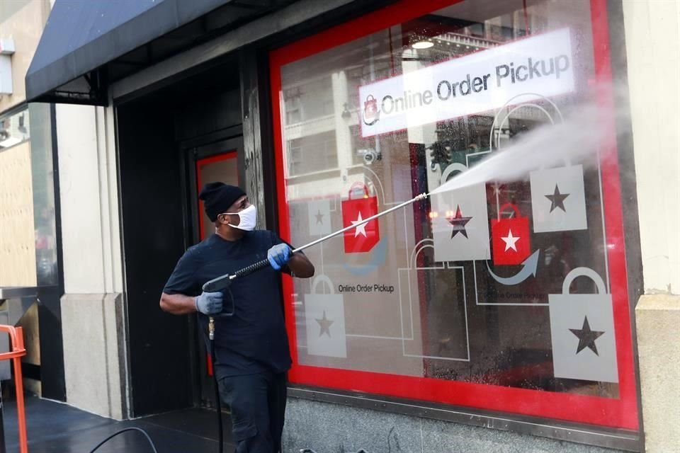 Un trabajador limpia la ventana de la oficina de recolección de pedidos de ordenes en línea de Macy's en Manhattan, Nueva York.