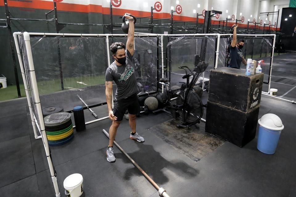 El CrossFit Tigram acondicionó, dentro de la 'nueva realidad' cabinas con paredes de plástico para hacer ejercicio.