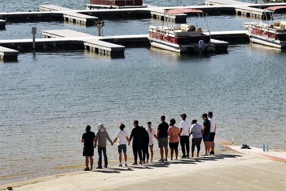 Allegados se reunieron a orillas del lago ayer, cuando encontraron el cuerpo.