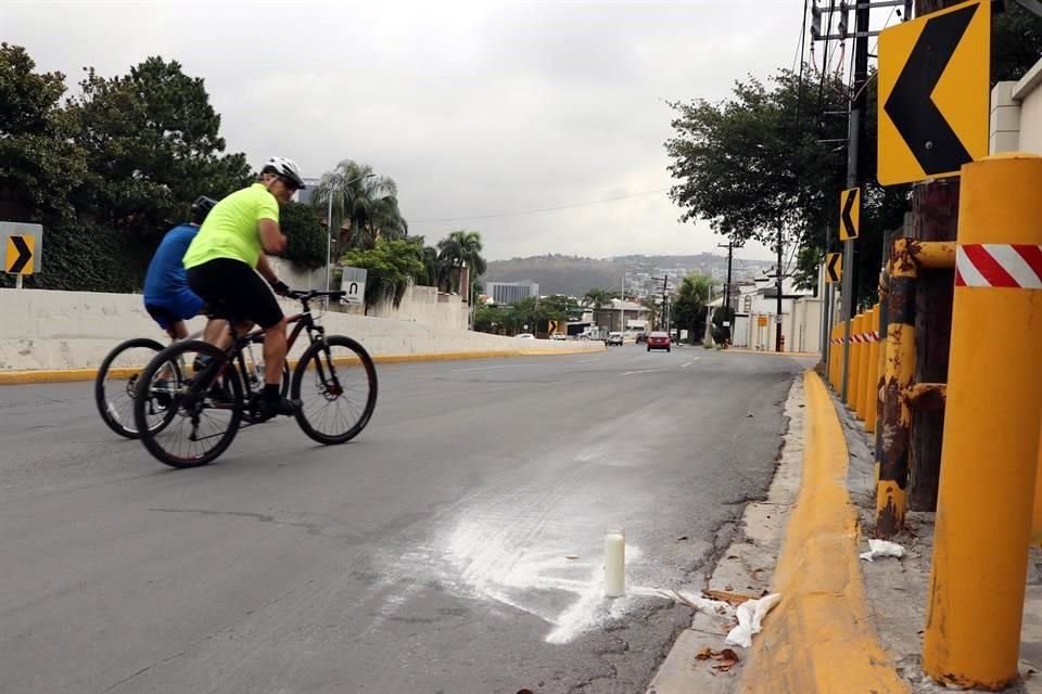 Decenas de deportistas en bicicletas o corriendo pasan por el lugar y algunos disminuyen la velocidad para persignarse.