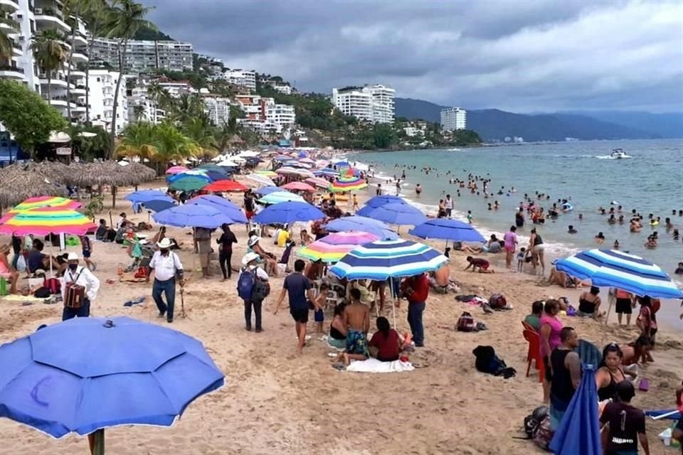 Personal de Protección Civil realiza recorridos en las playas de Puerto Vallarta para hacer recomendaciones de sanidad a los paseantes. No todos las acatan.