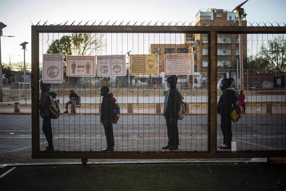 Niños sudafricanos hacen fila para entrar a la escuela en Johanesburgo.