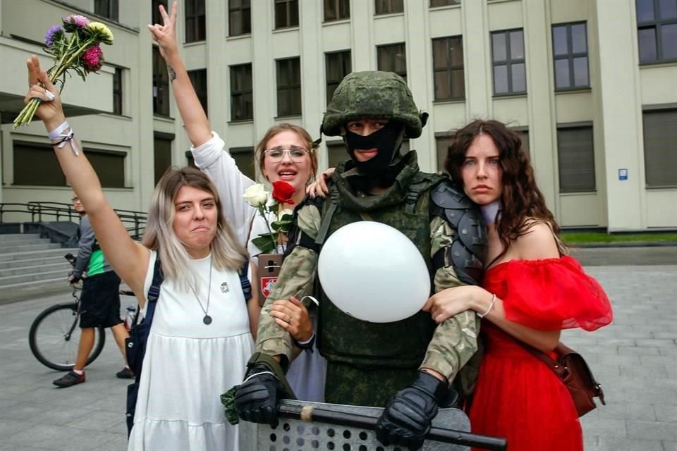 Mujeres abrazan a un soldado que mostró su apoyo a las protestas.