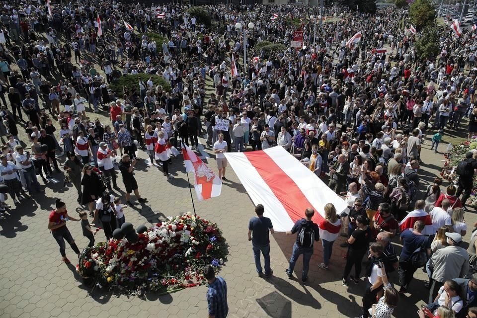 Los manifestantes muestran una vieja bandera de Bielorrusia en el sitio de la muerte de Taraikovsky.