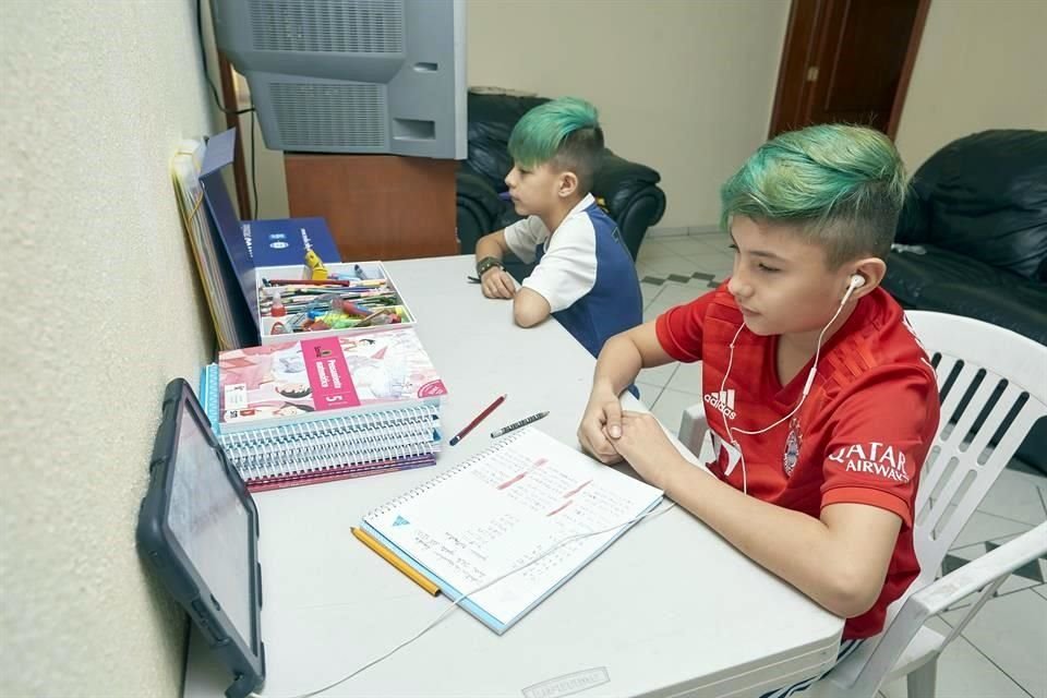 ... mientras sus hermanos Valentín y Emanuel toman clases en otro cuarto.
