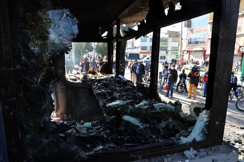 Ciudadanos observan hoy los restos incinerados del Centro de Atención Inmediata (CAI) La Gaitana de la Policía en la localidad de Suba, en Bogotá.