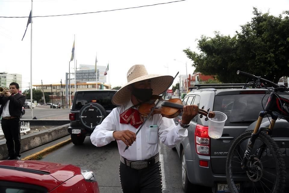 Cada que se pone en rojo el semáforo de Américas y Avenida México, los músicos deleitan con sus notas a quienes esperan el siga, a cambio de una moneda.