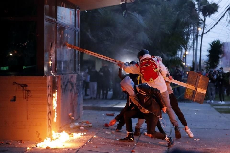 Un grupo de personas destruye un puesto de la policía.