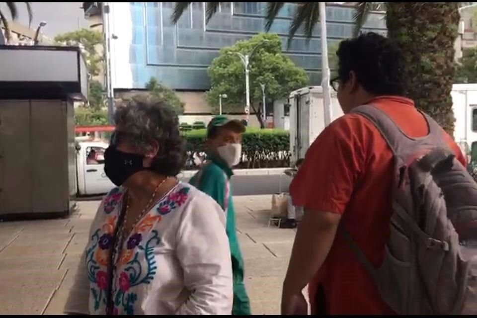 Compradores de cachitos siguieron el evento afuera del edificio de la Lotería Nacional a través de una pantalla.