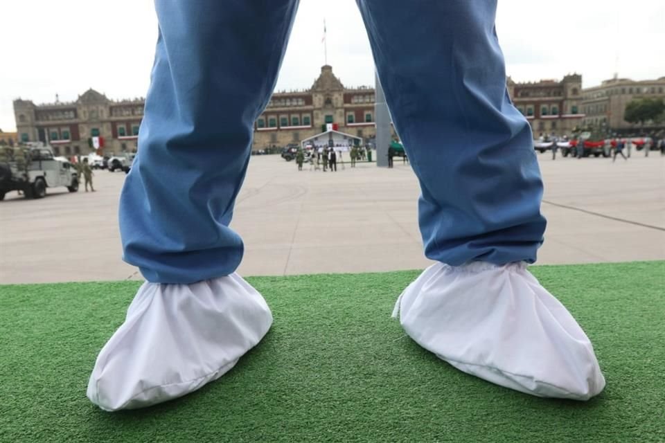 Un soldado con traje médico, usado para atender Covid-19, aguarda en un carro frente a Palacio Nacional.