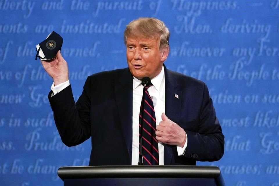 El Presidente Donald Trump muestra una mascarilla durante el primer debate.