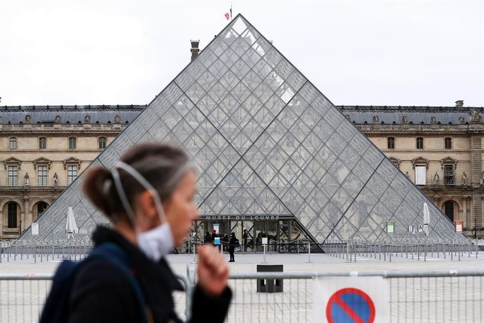 Una mujer camina frente al Museo del Louvre, que vuelve a cerrar sus puertas ante la segunda ola de Covid-19 en Europa.