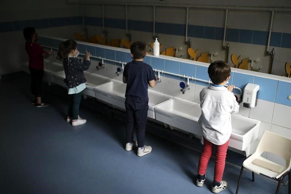 Un grupo de niños en grado escolar de primaria se lava las manos, luego de la reapertura de los contros escolares el Francia.