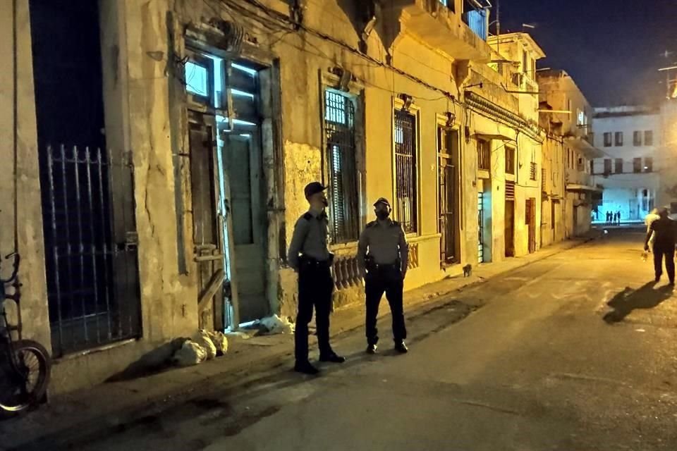 Dos policías permanecen afuera de la casa donde se encontraban los disidentes en huelga de hambre y sed, en la barriada de San Isidro, en La Habana, Cuba