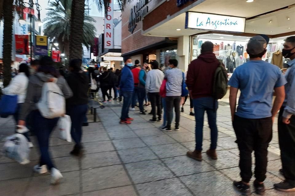 En algunas tiendas, los clientes hacen filas para entrar.